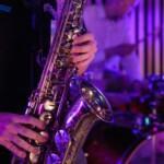 saxophone in foreground and drum kit in background jazz club atmosphere