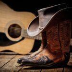 acoustic guitar, cowboy boots and leather cowboy hat